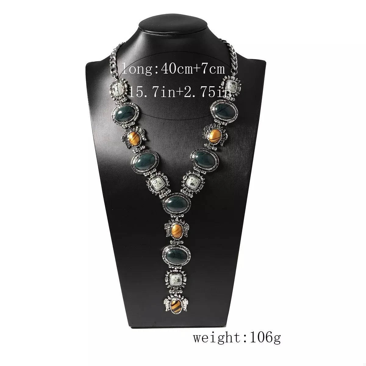 Resin zinc alloy Y-shape silver-plated necklace with green and amber stones on black display bust
