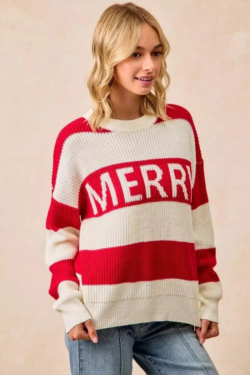 Woman wearing BiBi Christmas Merry Lettering Sweater in red and cream ribbed knit with bold MERRY text and oversized fit