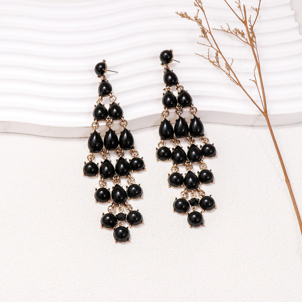 Alloy and rhinestone teardrop earrings with black stones and gold-tone metal detailing