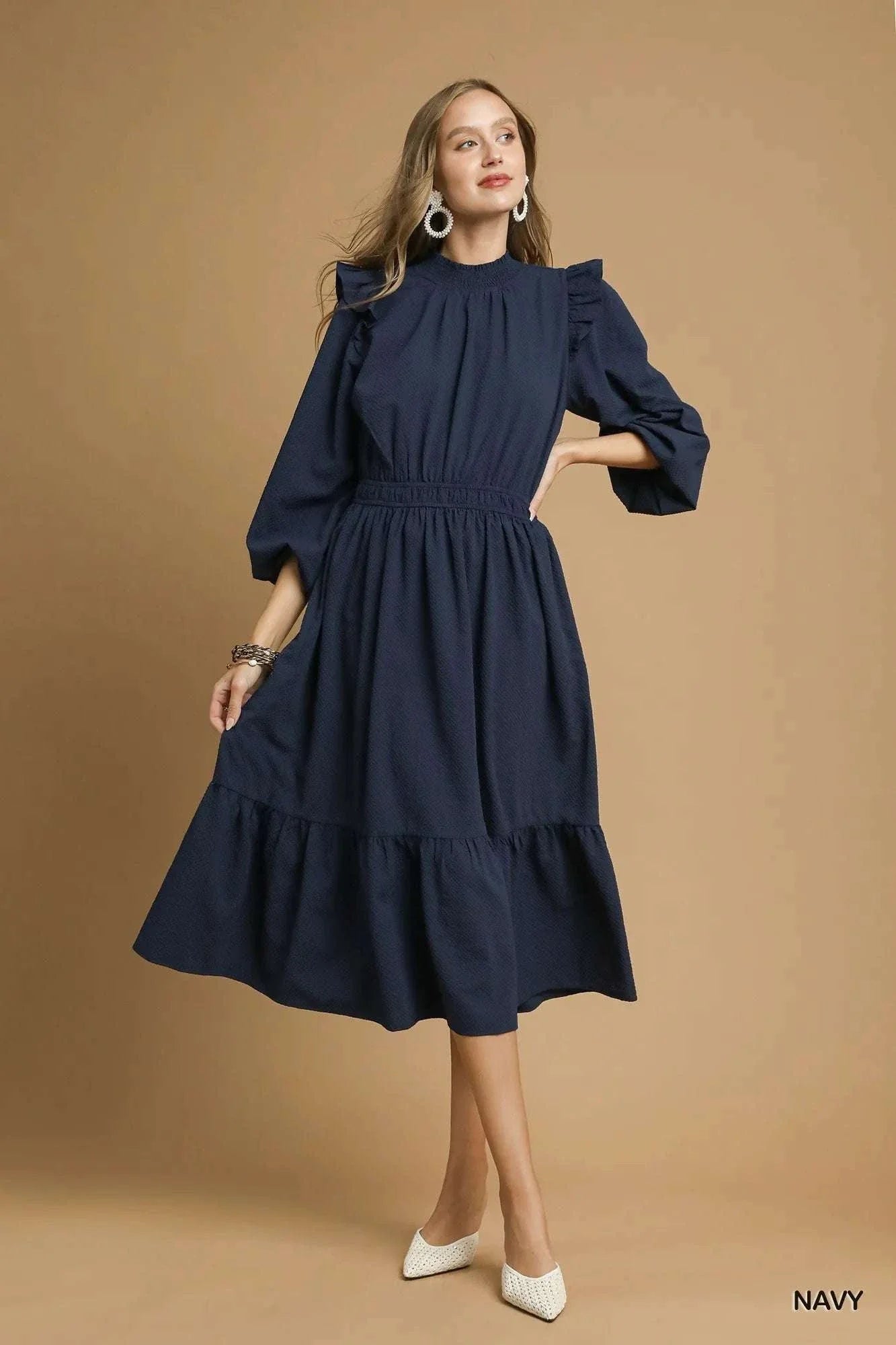 Woman wearing navy Umgee textured midi dress with ruffle shoulder detail and gathered waist