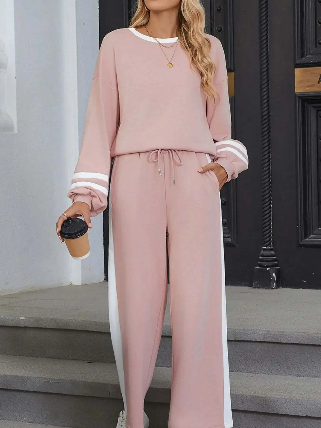 Woman wearing pink contrast trim round neck top and pants set with white stripes and drawstring waist