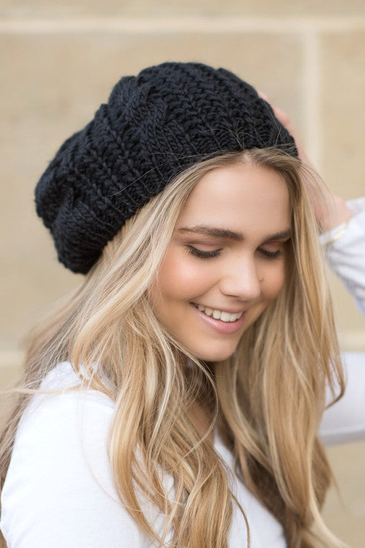 blonde woman wearing black knit slouchy beret smiling with eyes closed