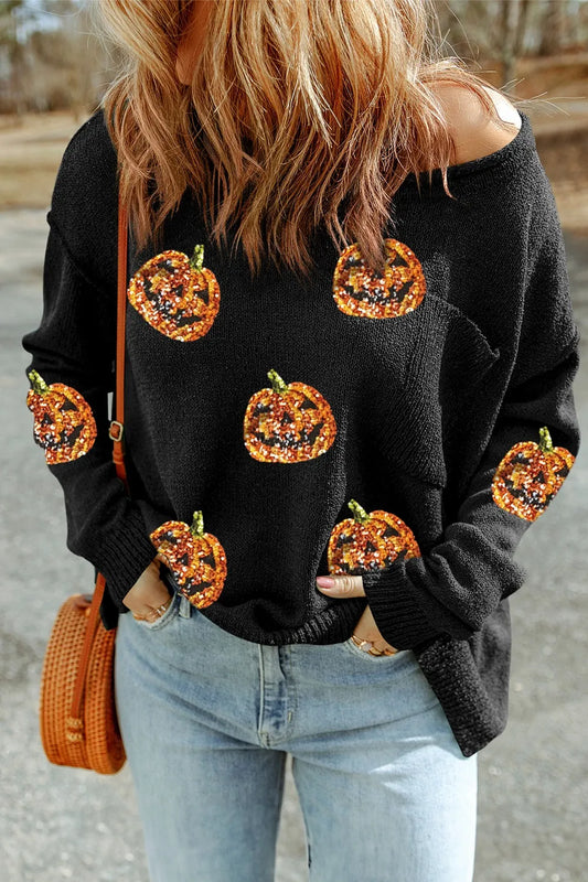 Black knit long sleeve top with sequined pumpkin designs, styled casually with light blue jeans and an orange woven bag.