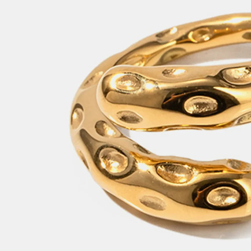 Close-up of gold-plated titanium steel bypass ring with textured design