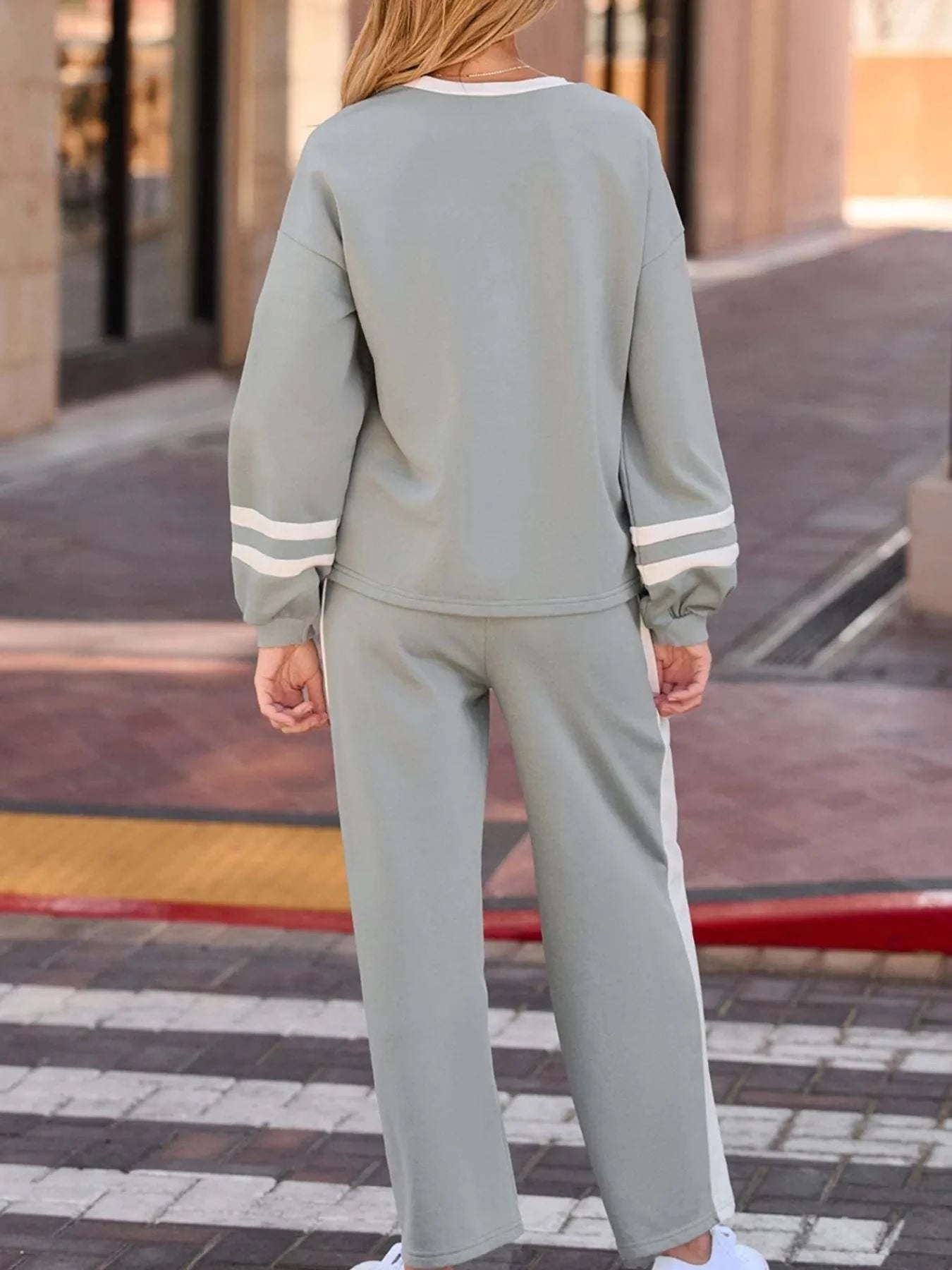Back view of a woman wearing a grey Contrast Trim Round Neck Top and Pants Set with white stripes on sleeves and pants