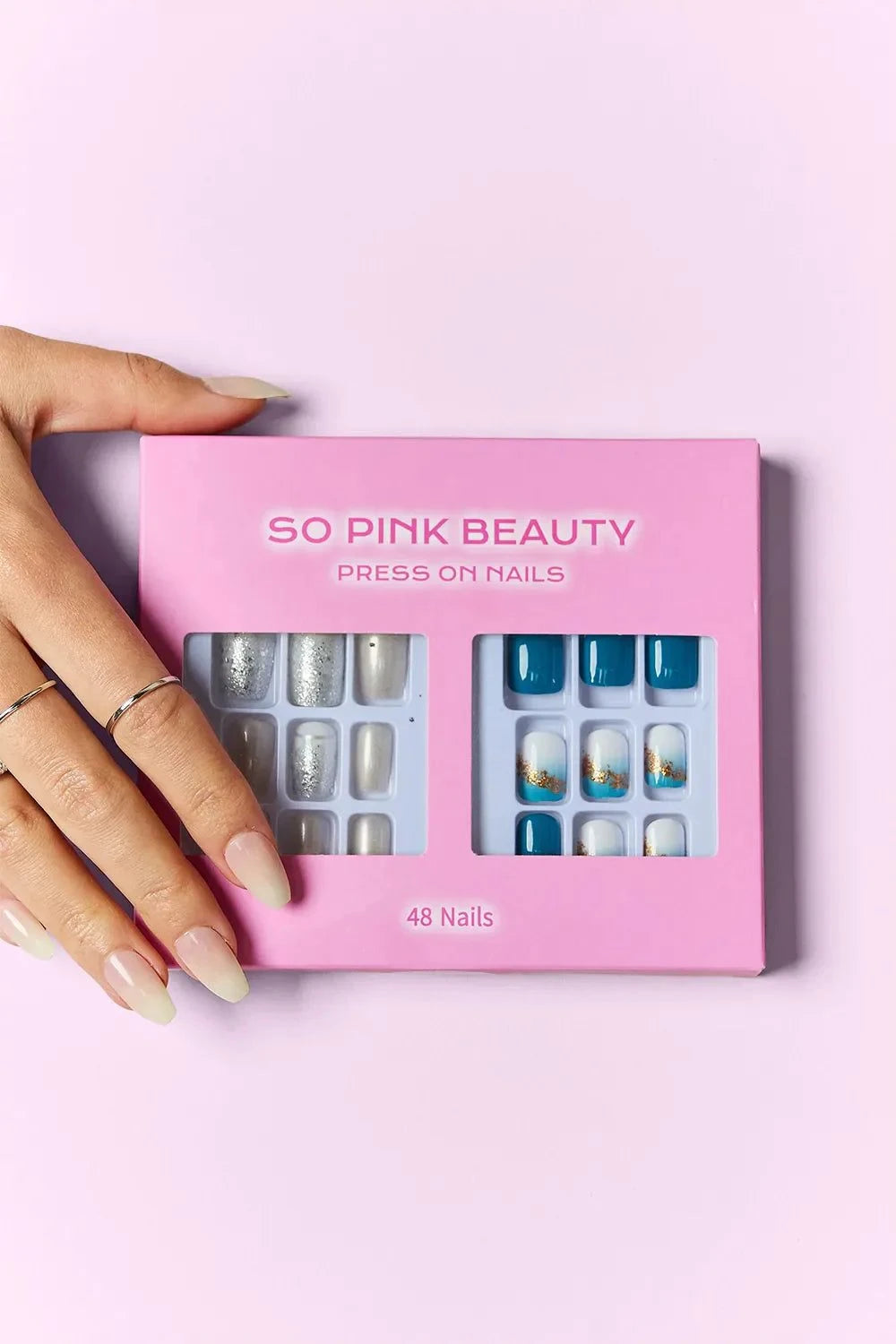 SO PINK BEAUTY press on nails two-pack with 48 pieces and glue in pink packaging held by hand