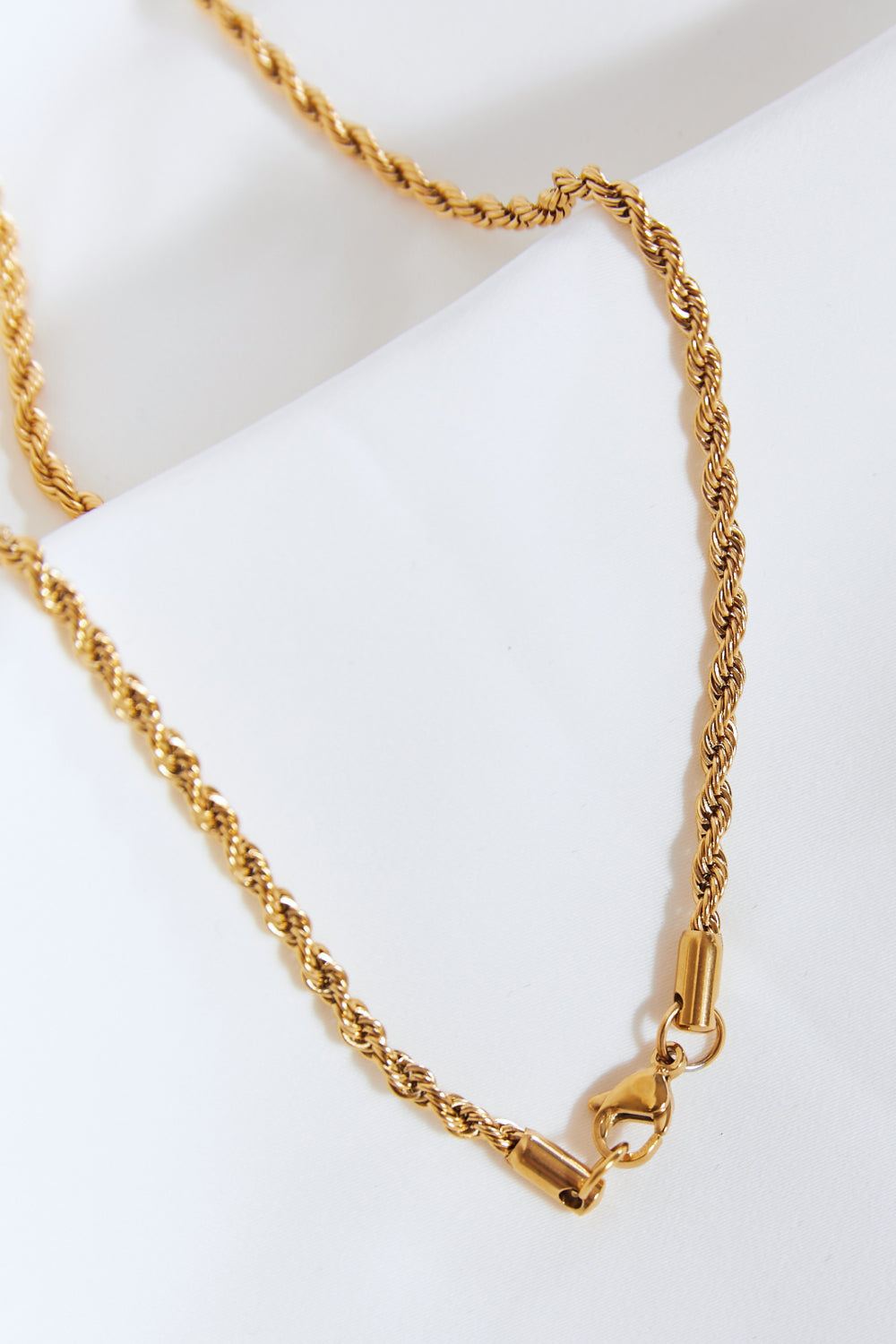 Close-up of a twisted brass chain for a brass lightning pendant necklace with a lobster clasp fastening