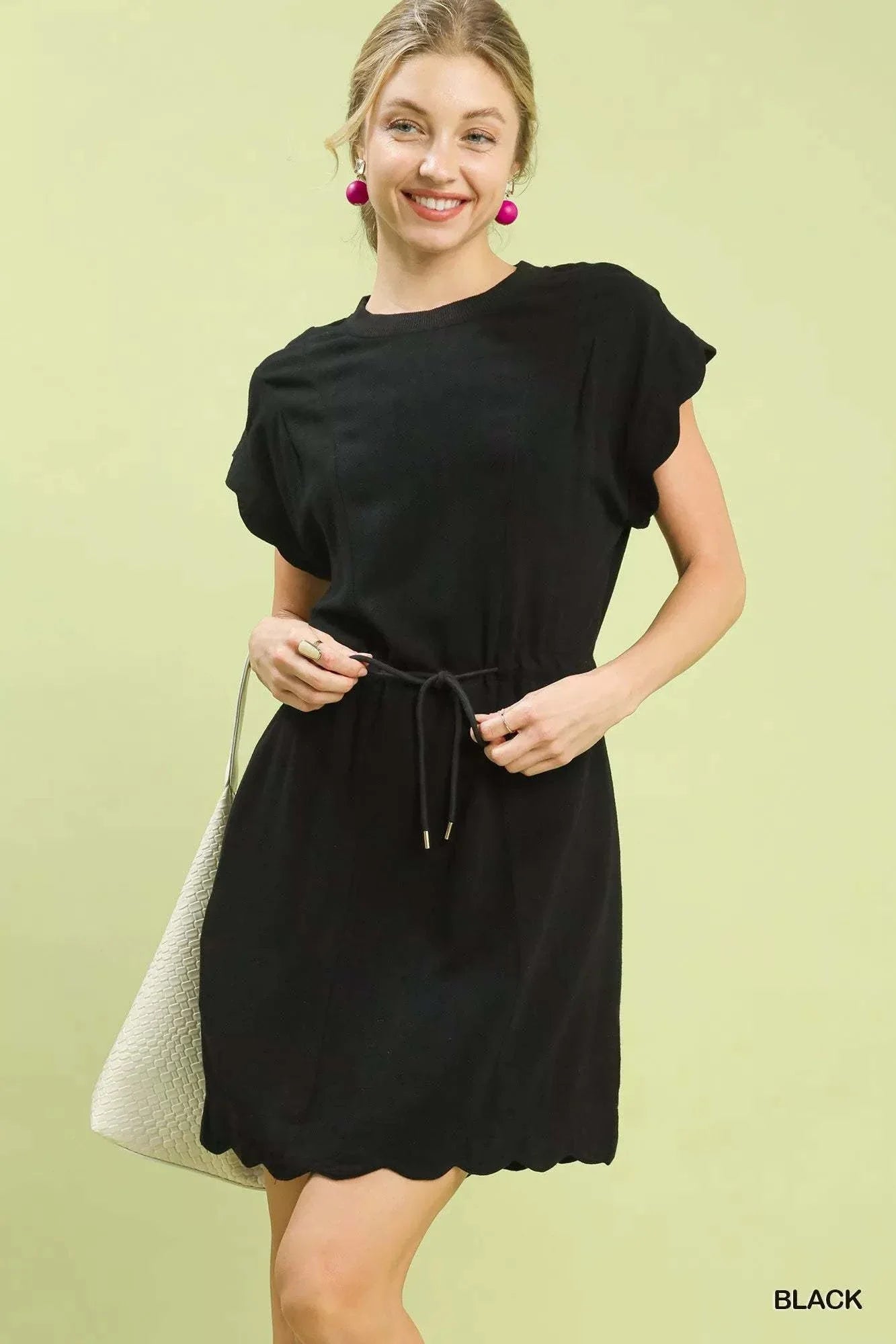 Woman wearing black Umgee Linen Blend scallop hem mini dress with drawstring waist and flutter sleeves