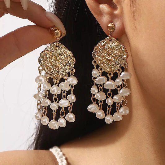 18K gold-plated dangle earrings with synthetic pearls on model's ear