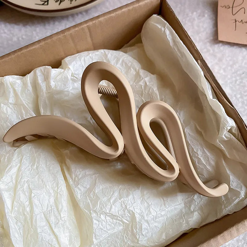 Beige alloy acrylic hair claw clip with wavy design in a box