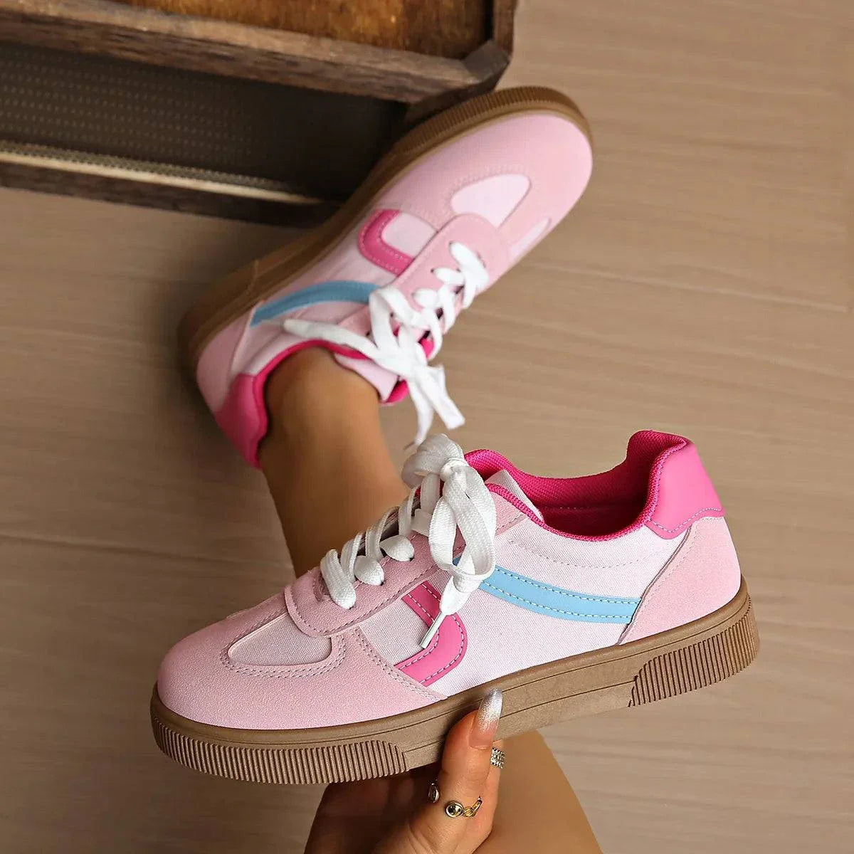 Pink and white lace up platform sneakers with blue accent and brown rubber sole