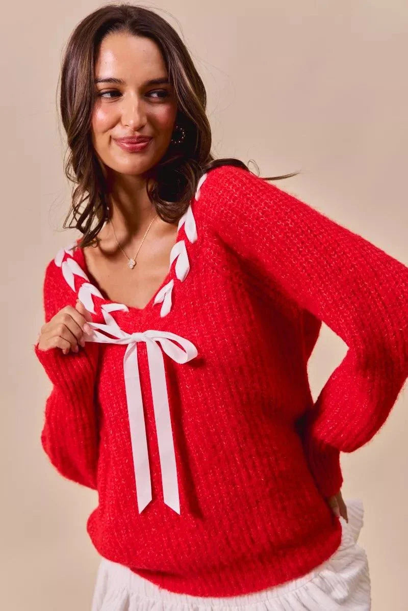 Red V-neck sweater with satin tape braided ribbon tie and long sleeves worn by woman