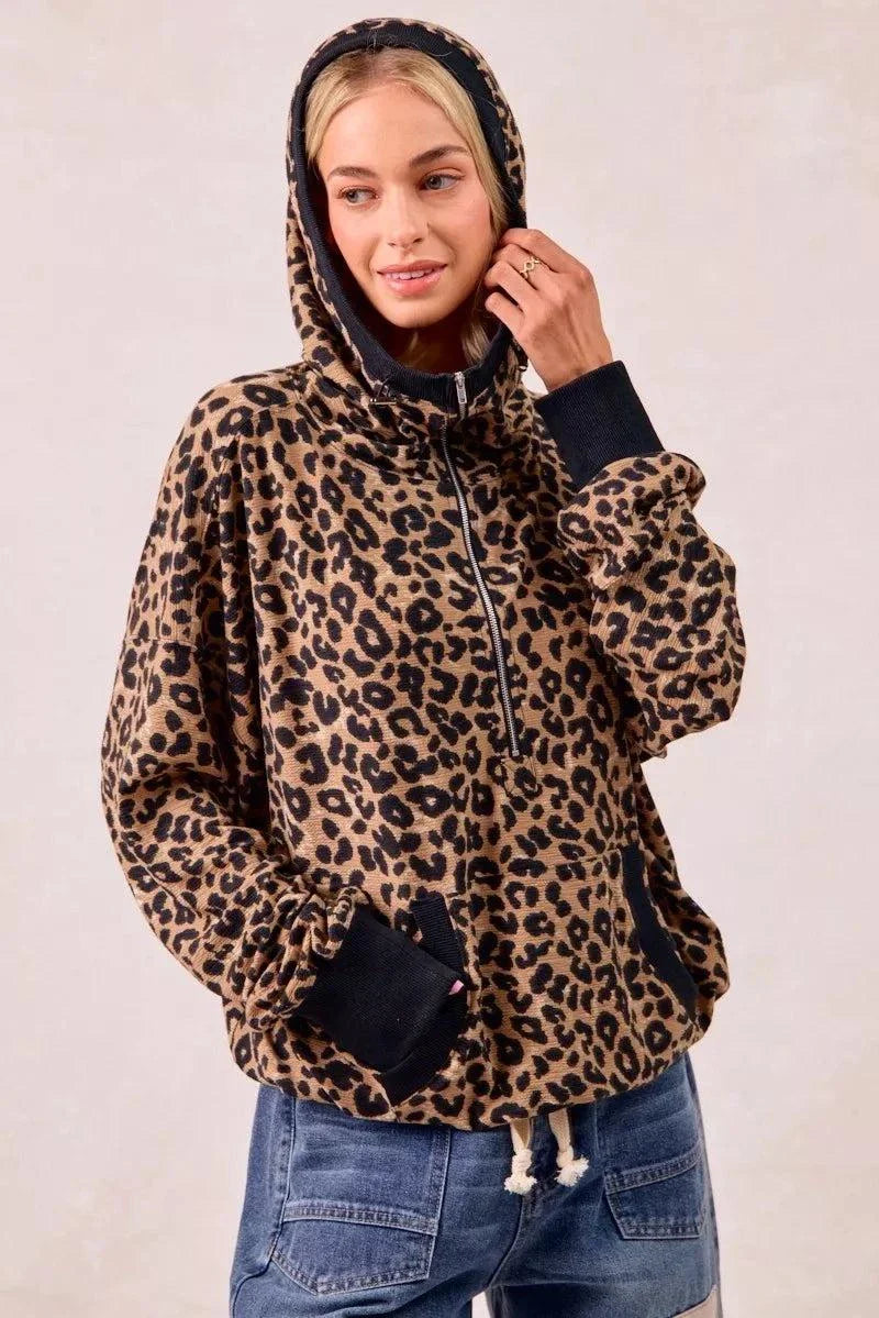 Woman wearing leopard print waffle knit half zip hoodie with front pocket and black cuffs