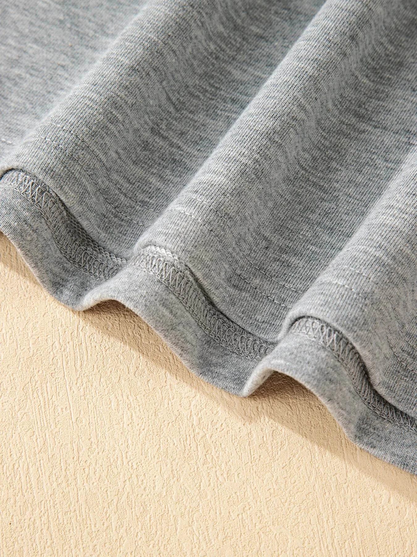 Close-up of grey fabric hem on contrast trim round neck top and pants set made of polyester and spandex blend