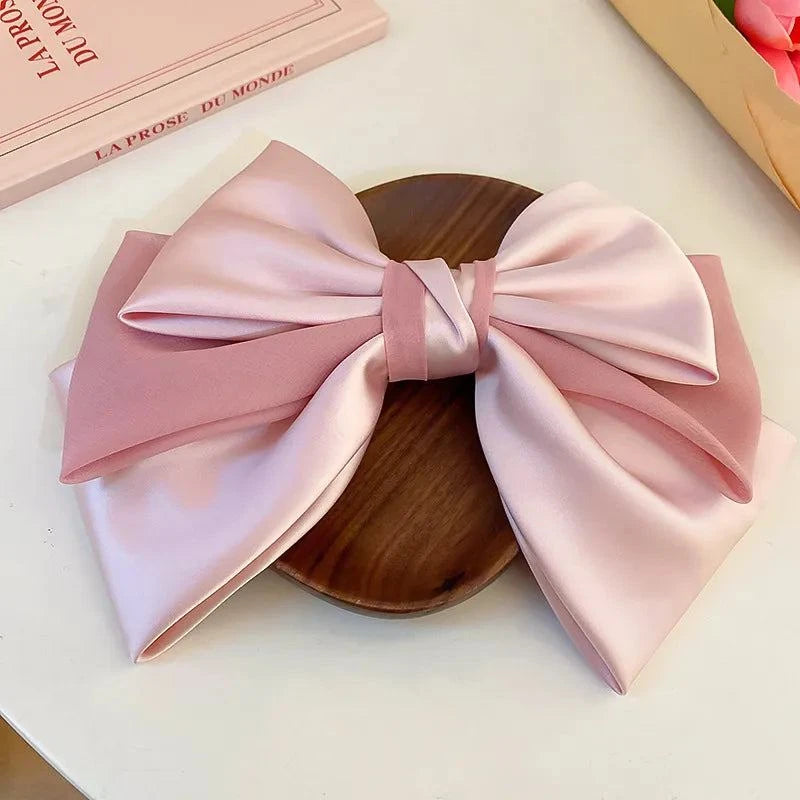 Pink and light pink bow cloth hair clip made of cloth and alloy, measuring 10.2 by 7.3 inches.