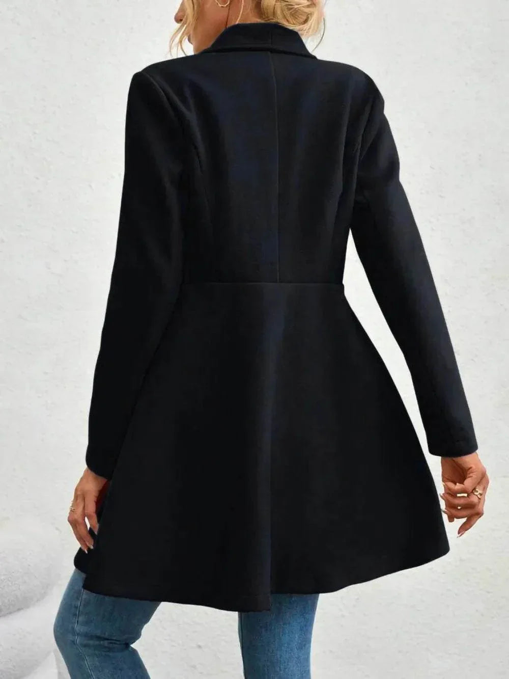 Black collared neck button up long sleeve coat with flared hem, made of 100% polyester, on a woman from the back.
