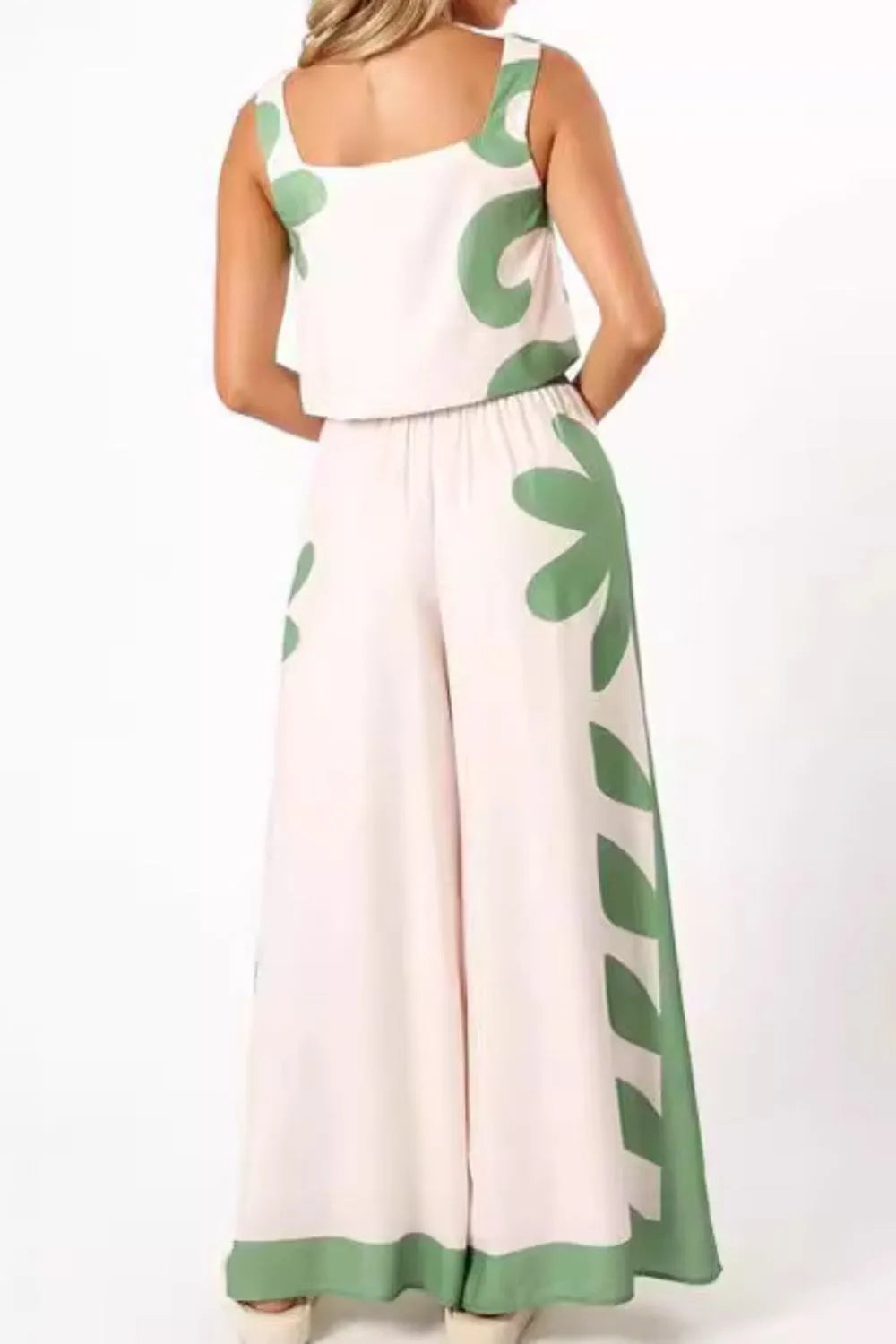 Woman wearing leaf print tank top and wide-leg pants set with green and white design