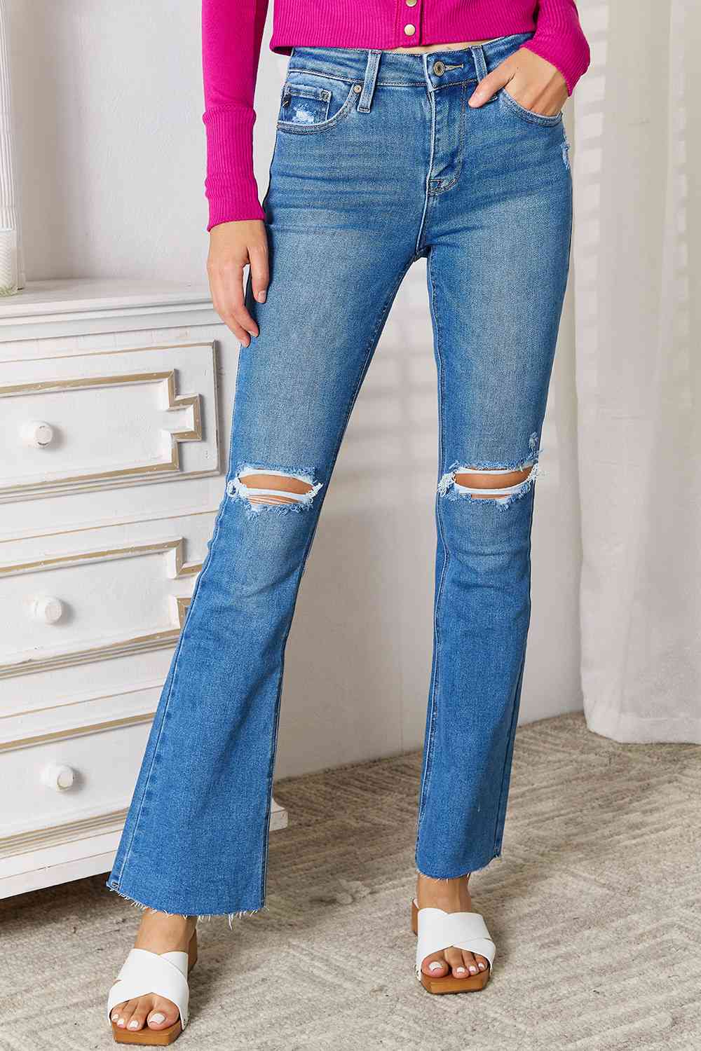 Full-size Kancan Distressed Bootcut Jeans with raw hem and ripped knees in blue denim.