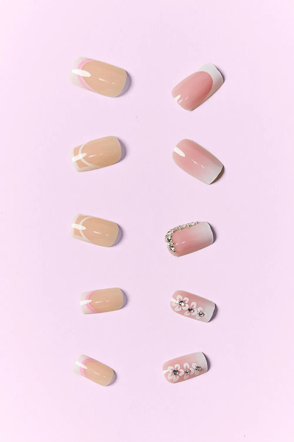 So Pink Beauty press on nails set with pink and nude designs including floral and rhinestone accents on a pink background