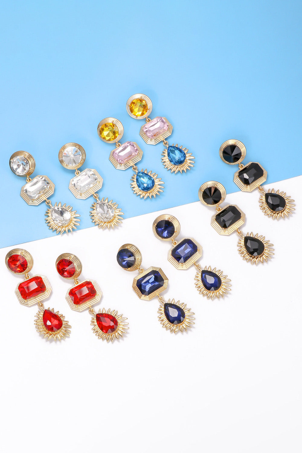 Collection of geometrical shape zinc alloy frame glass dangle earrings in various colors on blue and white background