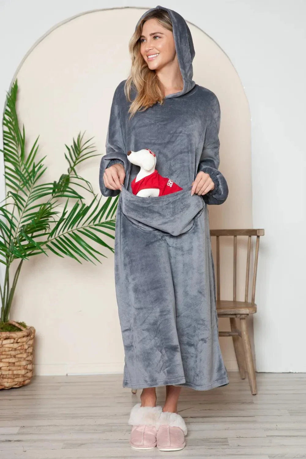 woman wearing grey hooded midi lounge dress with full-size pocket holding stuffed toy indoors