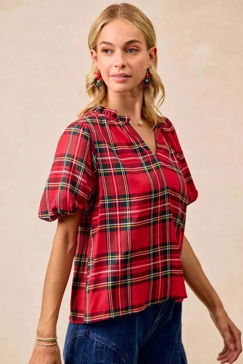 BiBi Christmas Plaid Short Sleeves Ruffled BlouseThis Christmas plaid short sleeves ruffled blouse is a festive and charming addition to your holiday wardrobe. The classic plaid pattern evokes a cheerful and cozy hChristmas plaid blouse