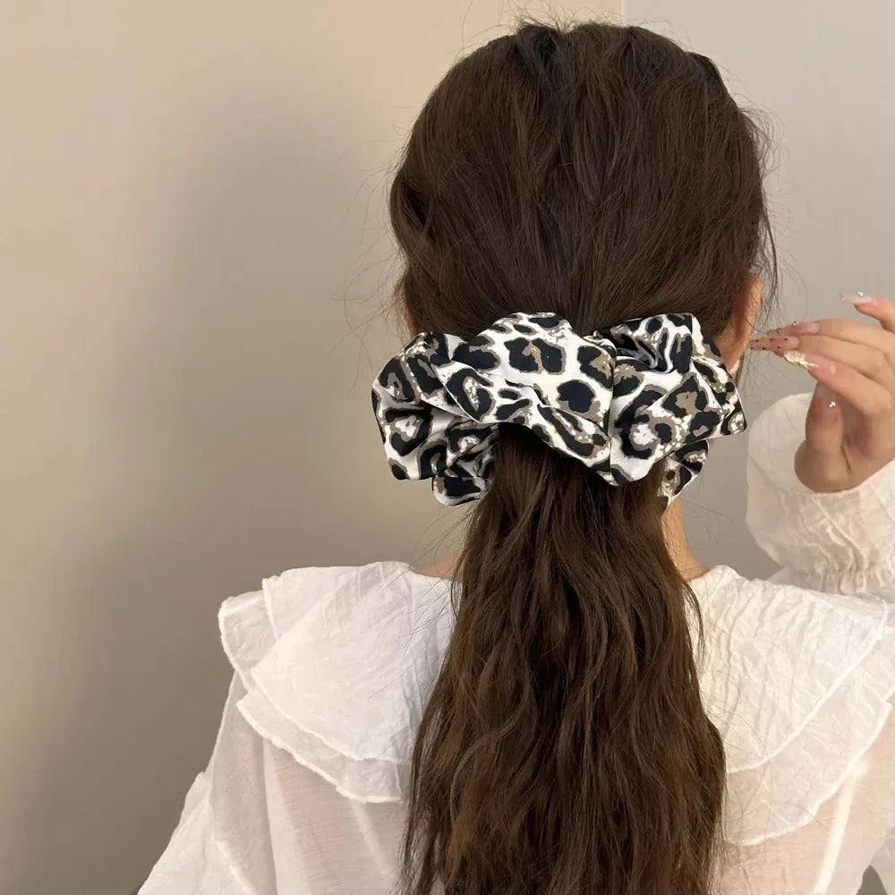 Leopard elastic hair scrunchy on brunette ponytail with white blouse background