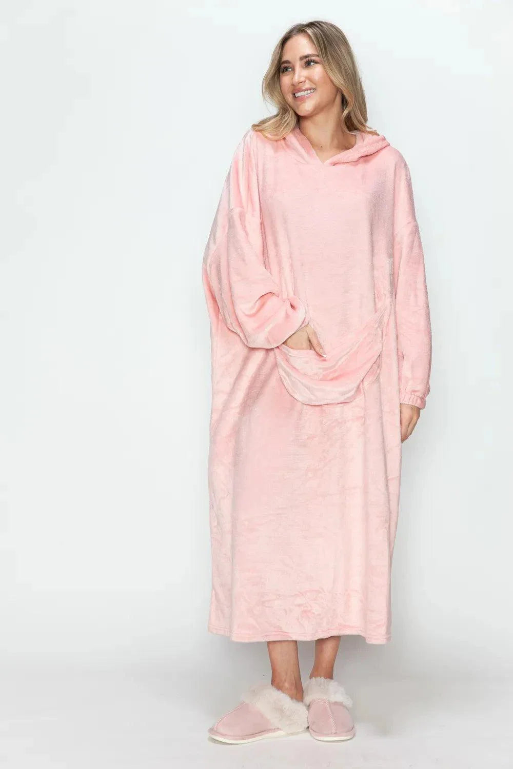 Woman wearing a pink hooded midi lounge dress with full-size pockets and slippers