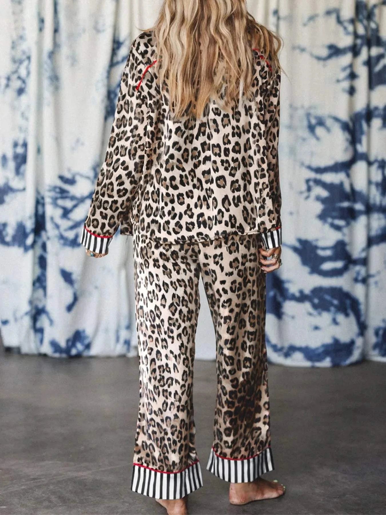 Back view of leopard and striped trim shirt and pants set with buttoned, drawstring, and pocketed design on a woman with long hair.