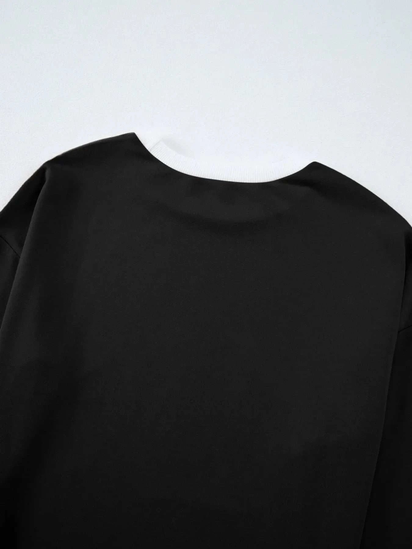 Black contrast trim round neck top fabric close-up with slight stretch and polyester spandex blend