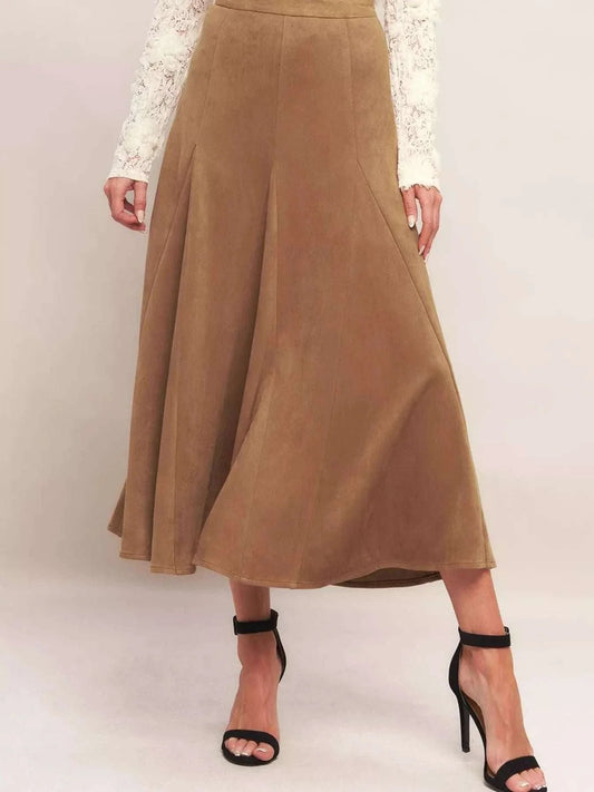 Camel brown flowy A-line midi skirt with high waist and elastic waistband, styled with black high heels.