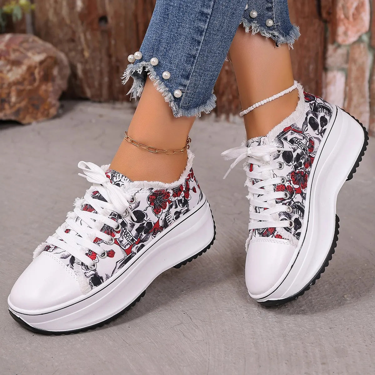 white and black printed platform sneakers with floral and skull design, lace-up style, worn with pearl-embellished frayed hem jeans