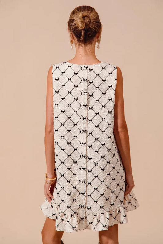 Back view of SO ME Texture Bow printed sleeveless mini dress with ruffle hem in black and white