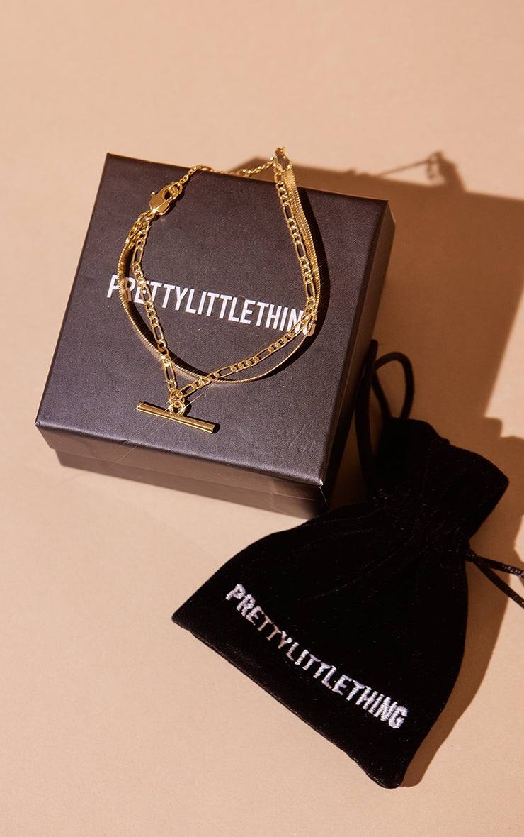 Real gold plated snake chain and T-bar multi bracelet on PrettyLittleThing box with black pouch