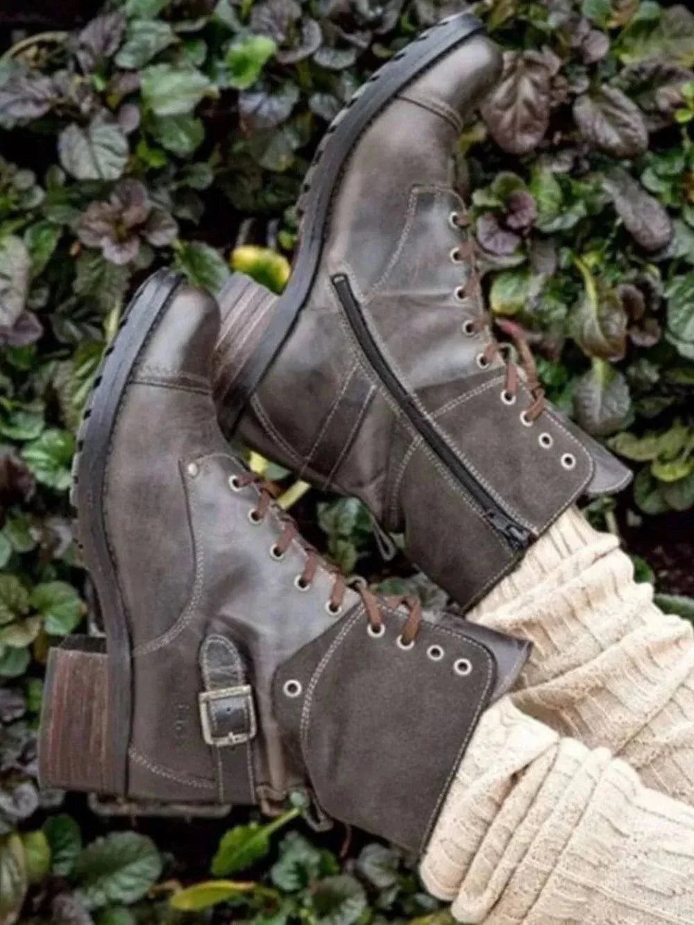 brown lace-up block heel boots with zipper and buckle detail on a leafy background