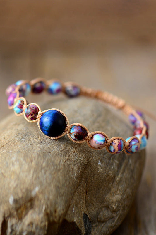 Imperial Jasper and natural stone beaded bracelet with adjustable braided cord on rock background