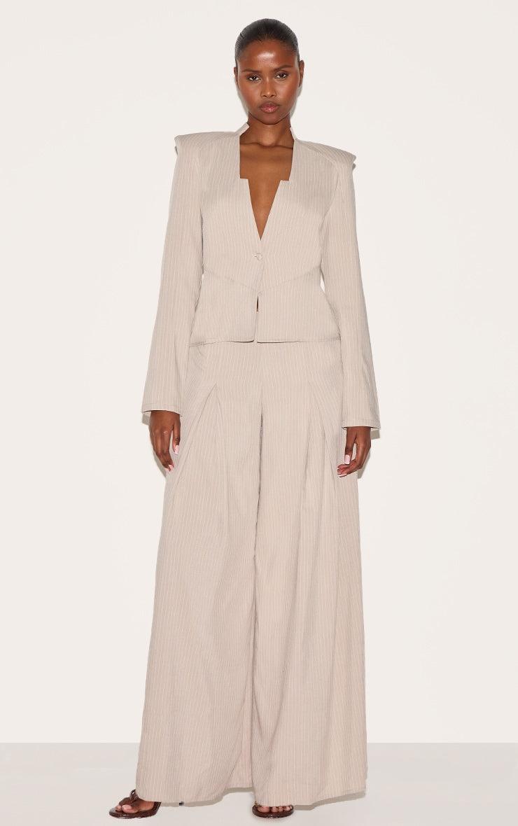 Tailored beige pinstripe jumpsuit with straight legs and shirt collar for evening wear