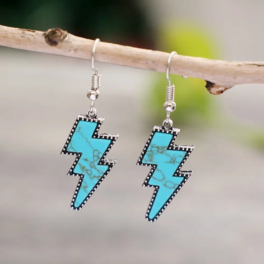Artificial turquoise lightning bolt silver-plated dangle earrings hanging on a branch