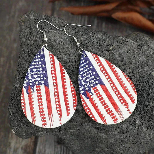 Teardrop shaped PU leather earrings with American flag design on textured gray stone background