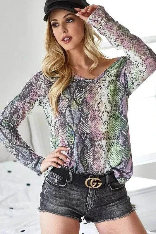 Woman wearing BiBi snakeskin print low gauge Hacci V neck top with denim shorts and black belt