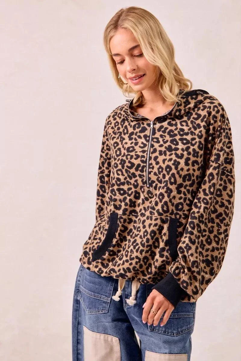 Leopard print waffle knit half zip hoodie with pocket and drawstring cuffs worn by woman