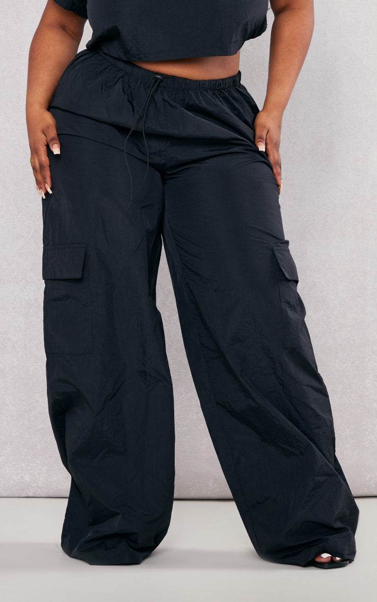 Plus Black Nylon Wide Leg Cargo TrousersReimagine your everyday uniform with these black nylon wide-leg cargo trousers. Cut from a durable, subtly textured nylon, they offer both structure and a relaxed siRedemption By Ashley NorthPlus Black Nylon