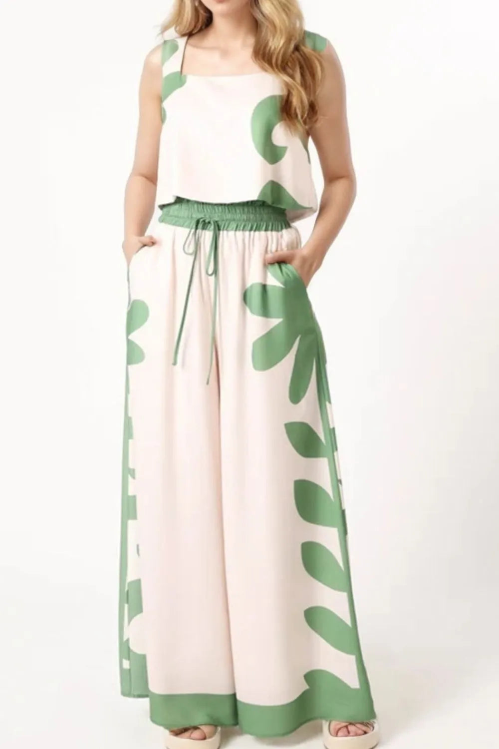 Woman wearing leaf print tank top and matching wide-leg pants set with drawstring waist