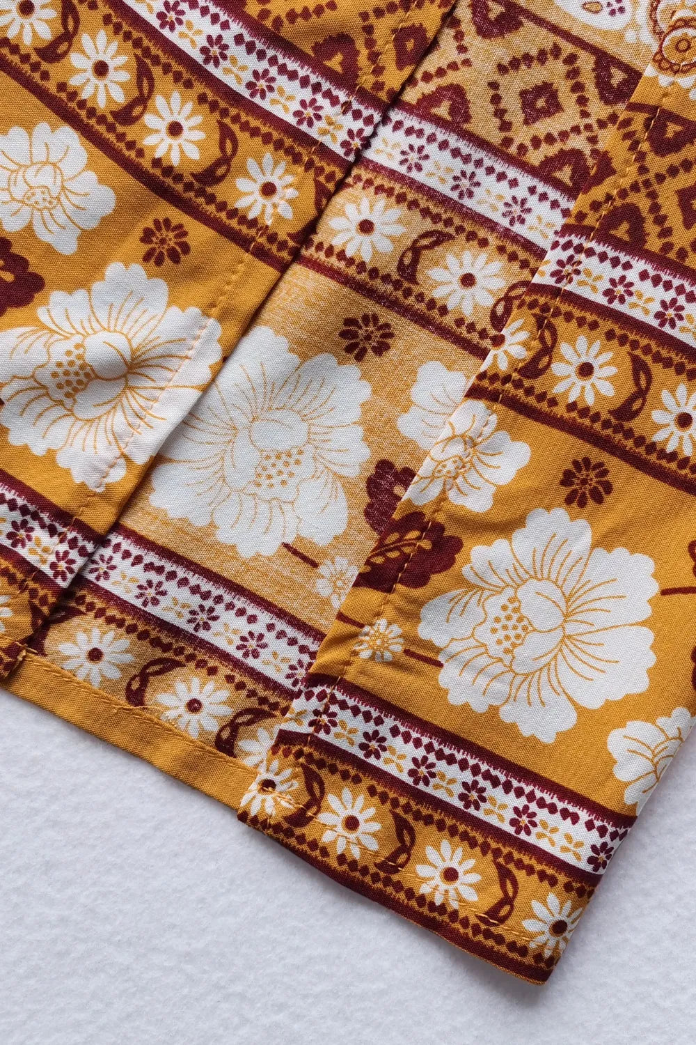 Printed half sleeve top with floral and geometric prints in mustard and white colors