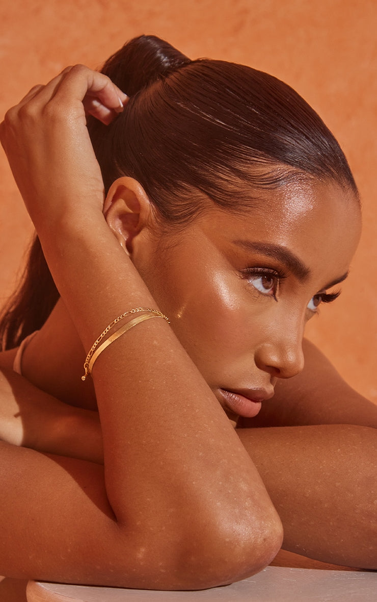 Real gold plated snake chain and T-bar multi bracelet on model's wrist