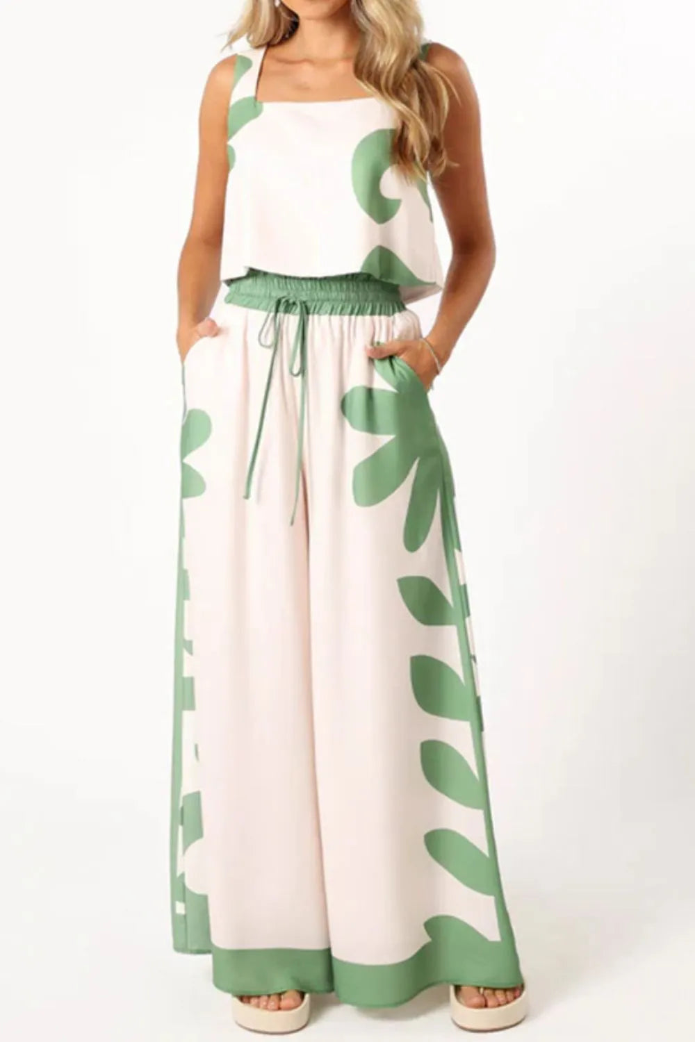 Woman wearing leaf print tank top and matching pants set with drawstring waist