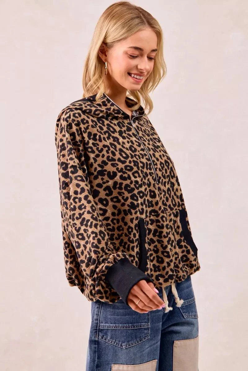 Woman wearing leopard print waffle half zip hoodie with pocket and drawstring hem