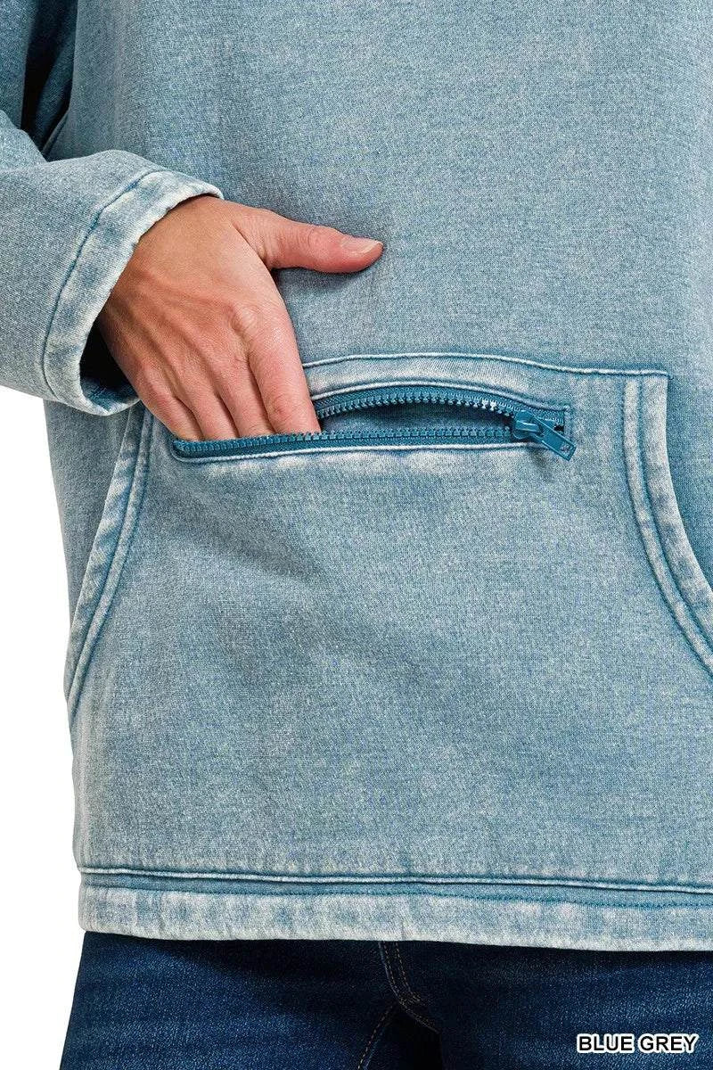 Close-up of fleece washed high neck sweatshirt in blue grey with zippered kangaroo pocket and hand inside pocket