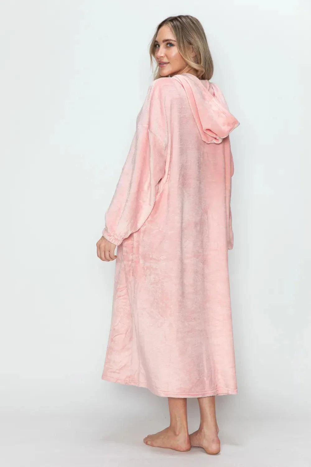 Woman wearing a soft pink hooded midi lounge dress with full-size pockets, shown from the back