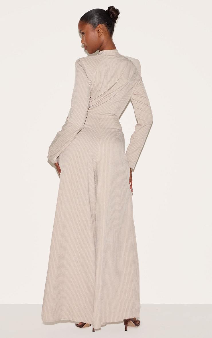 Back view of beige pinstripe shirt detail straight leg jumpsuit on model against plain background
